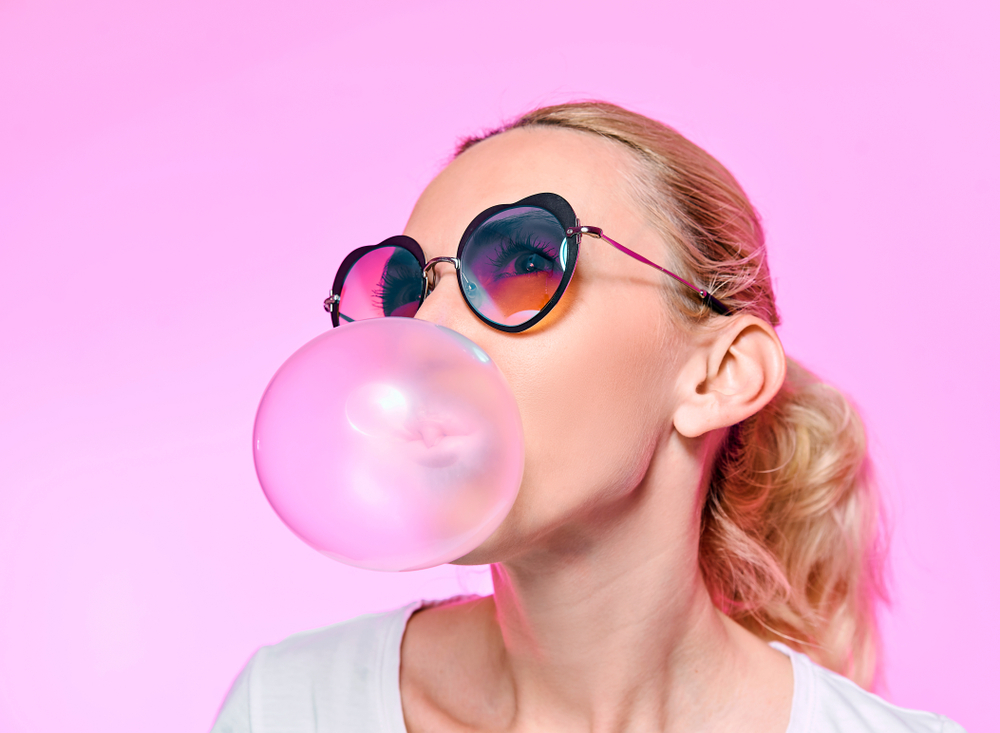 woman blowing pink bubble-gum bubble